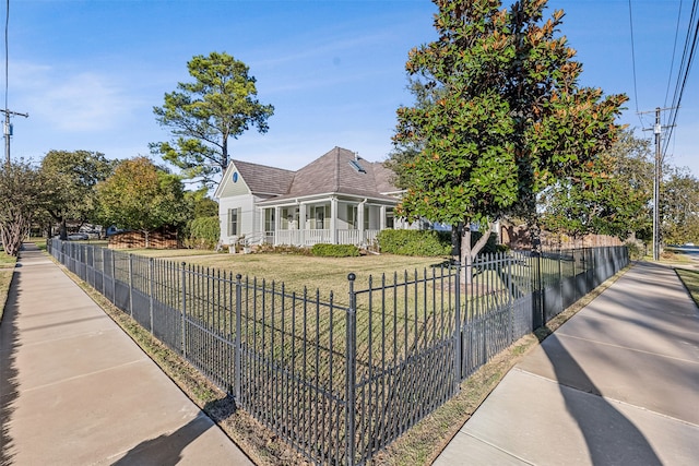 view of front of property featuring a sunroom and a front lawn