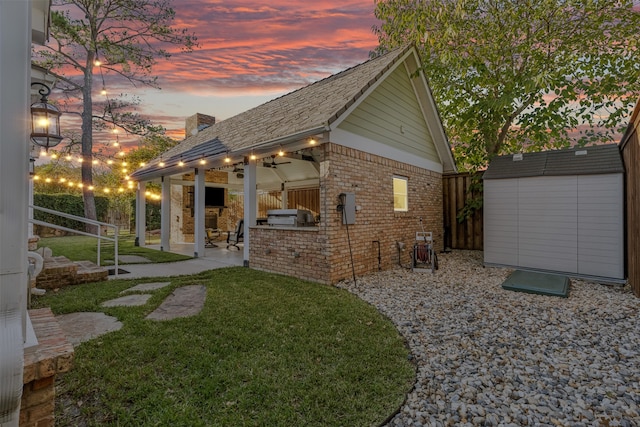 exterior space featuring ceiling fan, a yard, exterior kitchen, and a patio