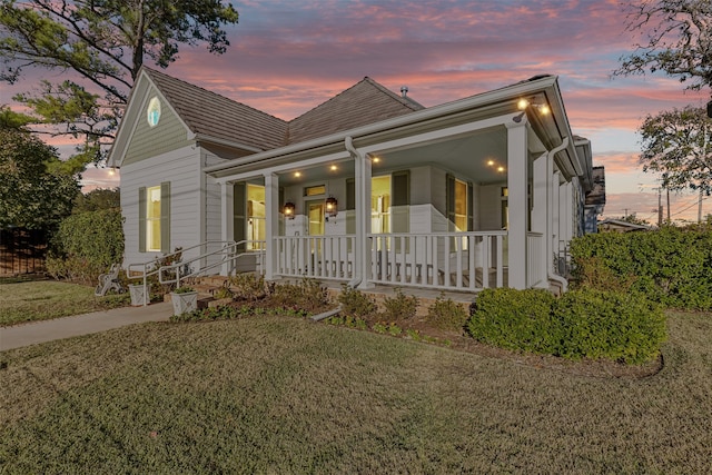 view of front facade with a porch and a lawn