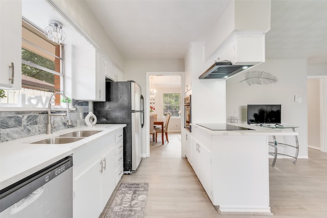 kitchen featuring white cabinets, appliances with stainless steel finishes, light hardwood / wood-style floors, and sink