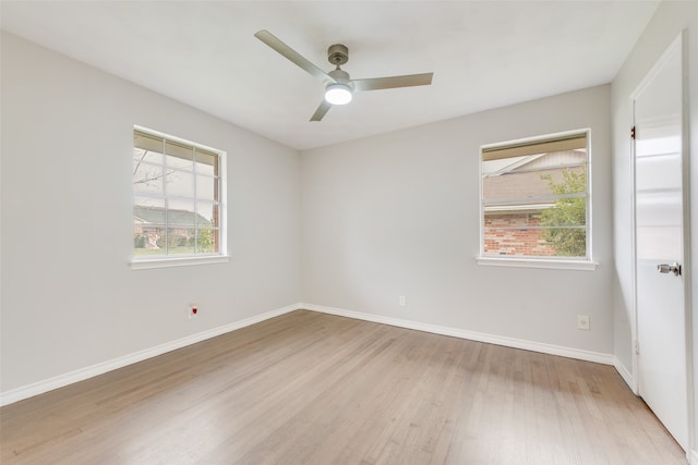 spare room featuring ceiling fan, light hardwood / wood-style flooring, and a healthy amount of sunlight