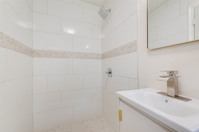 bathroom featuring a tile shower and sink