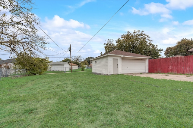 view of yard with a garage and an outbuilding