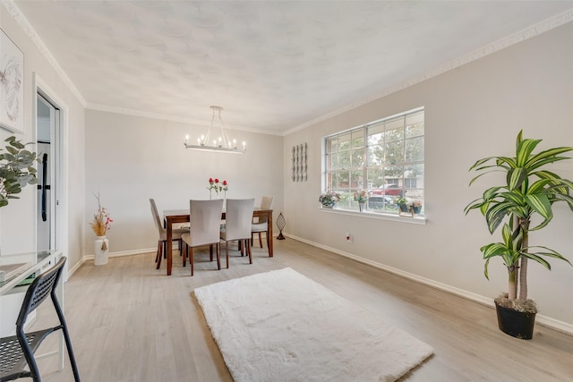 dining space featuring crown molding, light hardwood / wood-style flooring, and a chandelier