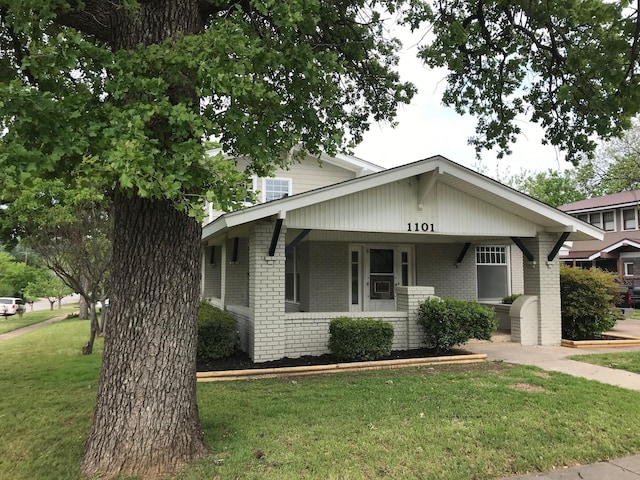 view of front facade featuring covered porch and a front lawn