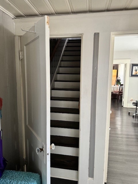 staircase with hardwood / wood-style flooring and crown molding