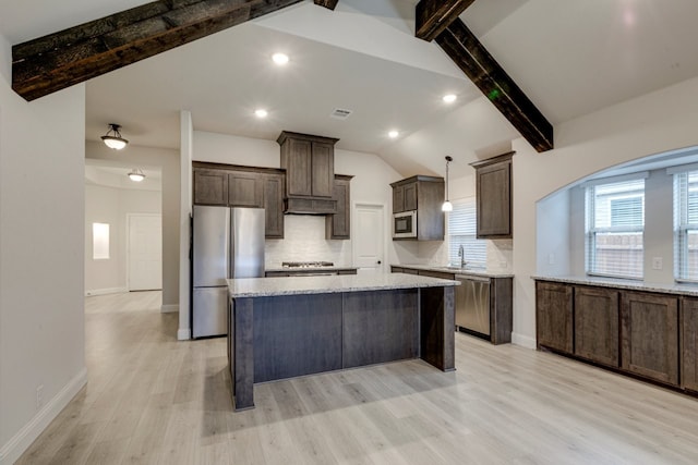 kitchen with tasteful backsplash, vaulted ceiling with beams, hanging light fixtures, stainless steel appliances, and light stone countertops