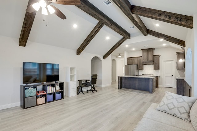 living room featuring ceiling fan, light hardwood / wood-style floors, and vaulted ceiling with beams