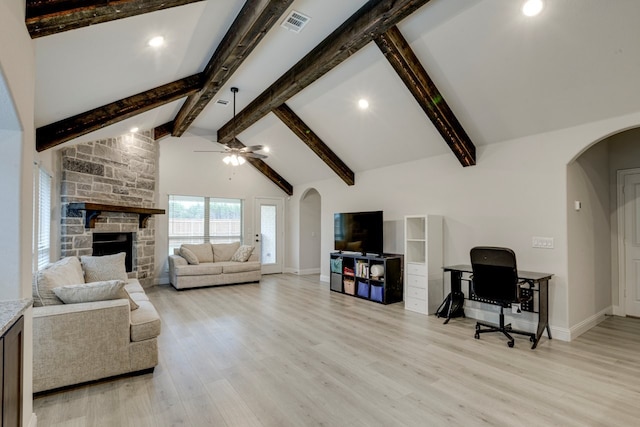 living room with high vaulted ceiling, a fireplace, beamed ceiling, ceiling fan, and light hardwood / wood-style flooring