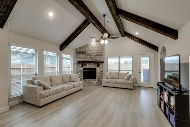 living room featuring a fireplace, a wealth of natural light, high vaulted ceiling, and light wood-type flooring