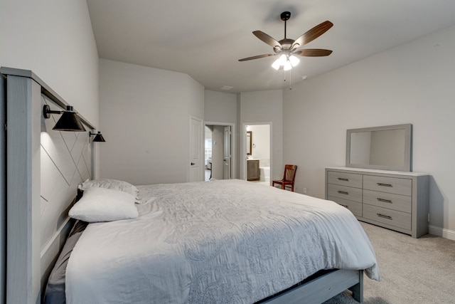 bedroom featuring ensuite bath, light colored carpet, and ceiling fan