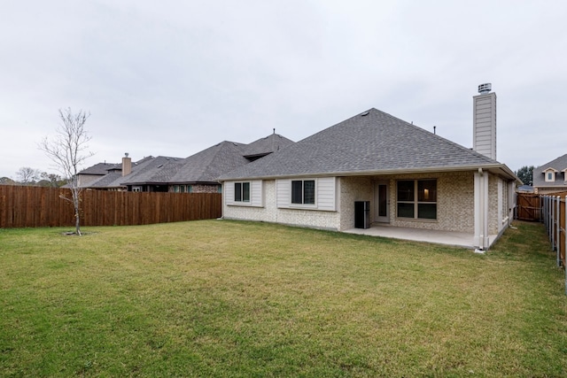 rear view of property with a yard and a patio