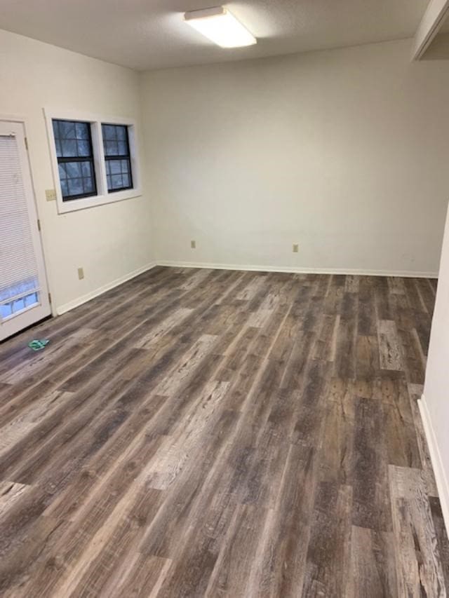 unfurnished room with dark hardwood / wood-style flooring