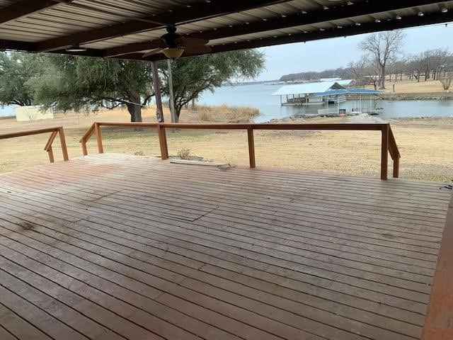 deck with ceiling fan and a water view