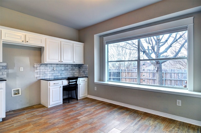 kitchen with decorative backsplash, light wood-type flooring, white cabinetry, and a wealth of natural light