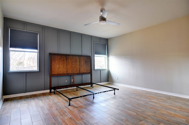 unfurnished bedroom featuring ceiling fan, light hardwood / wood-style flooring, and multiple windows