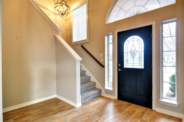 entryway featuring hardwood / wood-style flooring, a notable chandelier, and a wealth of natural light