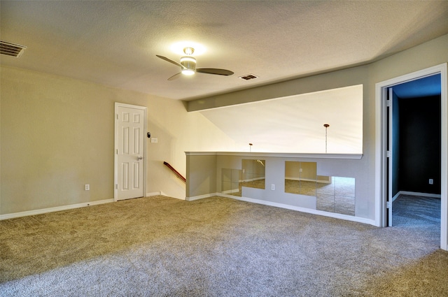 carpeted spare room featuring ceiling fan, beam ceiling, and a textured ceiling