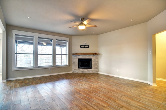 unfurnished living room with a fireplace, ceiling fan, light hardwood / wood-style flooring, and a textured ceiling