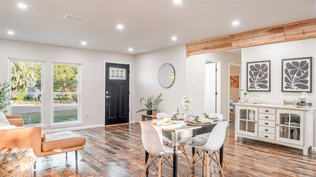 dining room featuring beamed ceiling and dark hardwood / wood-style flooring