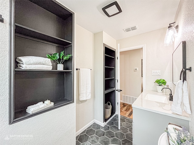 bathroom featuring tile patterned flooring, a textured ceiling, and vanity