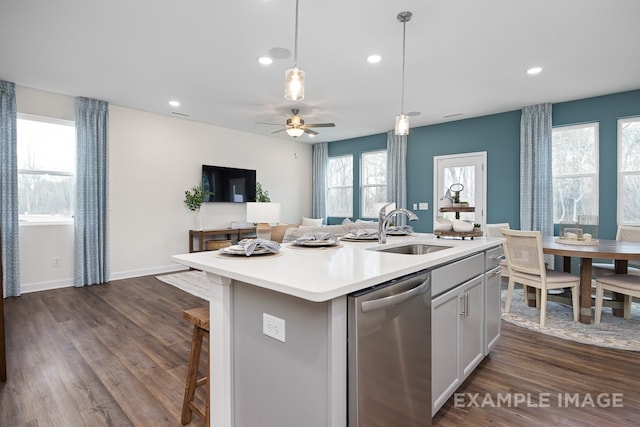 kitchen featuring a wealth of natural light, dishwasher, an island with sink, and dark hardwood / wood-style floors