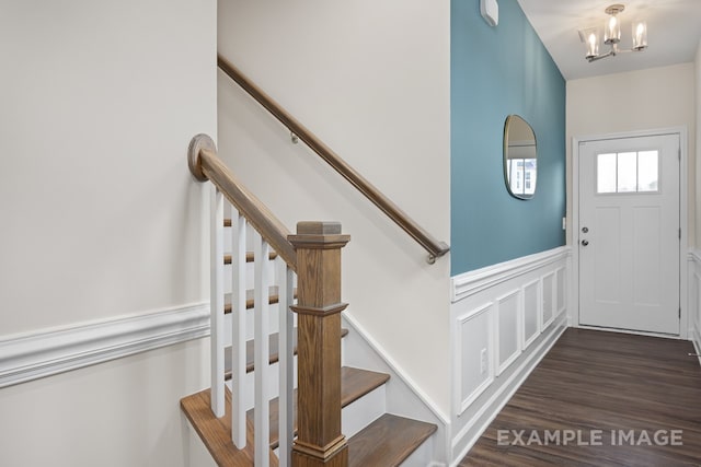 entrance foyer featuring dark wood-type flooring and an inviting chandelier