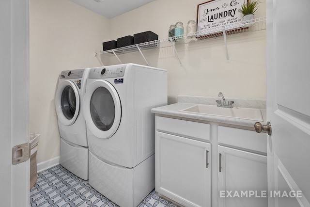 laundry area featuring washer and dryer, cabinets, and sink