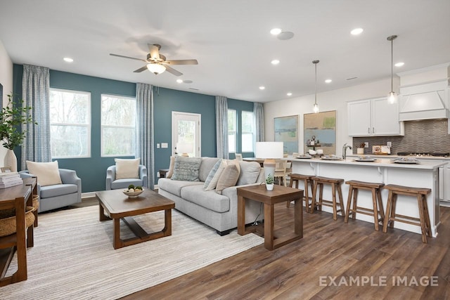 living room featuring ceiling fan, plenty of natural light, and light hardwood / wood-style floors