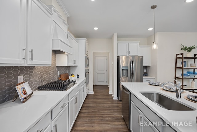 kitchen with sink, hanging light fixtures, dark hardwood / wood-style flooring, white cabinetry, and stainless steel appliances