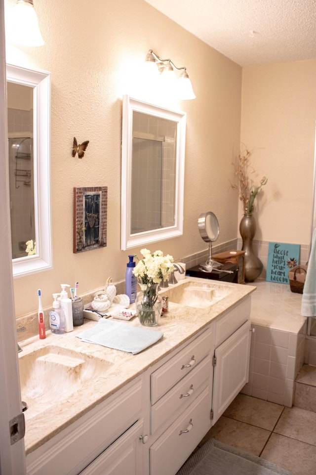 bathroom featuring tile patterned flooring, vanity, and a textured ceiling