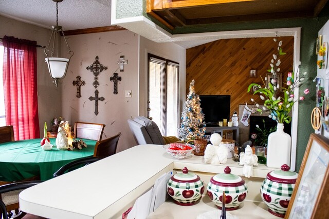 dining space with wood walls and a textured ceiling