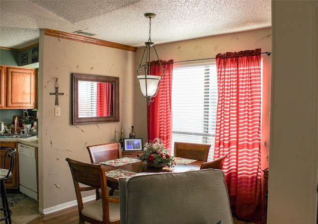 dining room with wood-type flooring and a textured ceiling