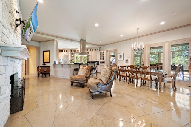 living room featuring ornamental molding, a stone fireplace, and a chandelier