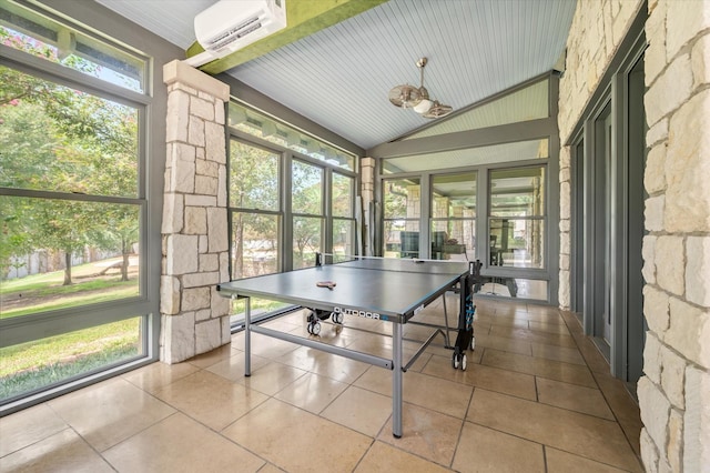 rec room featuring tile patterned flooring, vaulted ceiling, and a wall unit AC