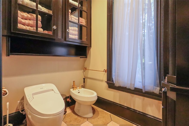 bathroom with a bidet, tile patterned floors, and toilet