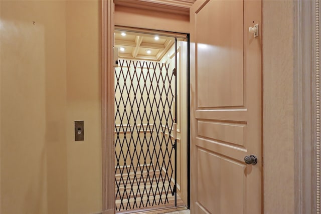 interior details with elevator, coffered ceiling, and beam ceiling