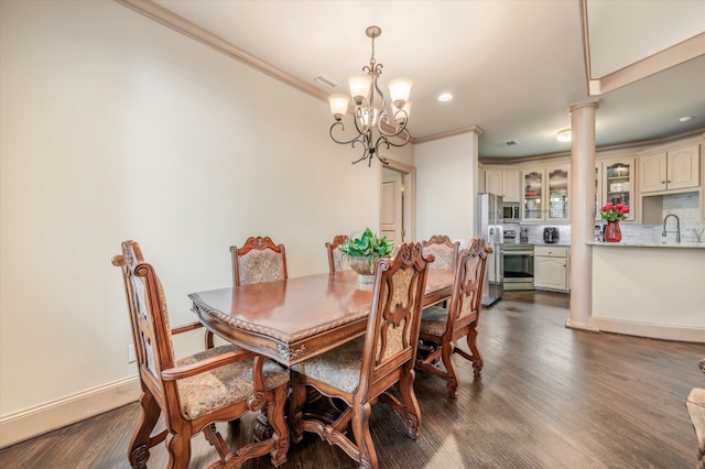 dining room featuring crown molding, dark hardwood / wood-style flooring, sink, and decorative columns