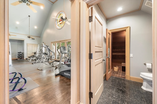 gym featuring crown molding, ceiling fan, and high vaulted ceiling