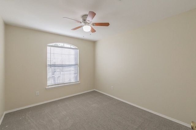 carpeted spare room featuring ceiling fan