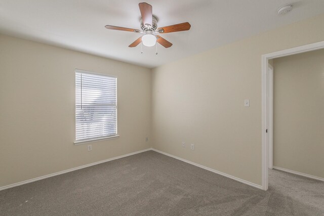 spare room with ceiling fan and carpet