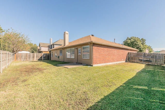 back of house featuring a lawn and a patio