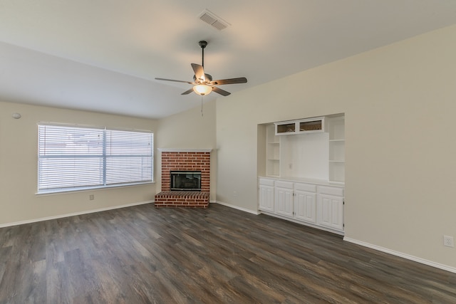 unfurnished living room with lofted ceiling, a fireplace, dark wood-type flooring, and ceiling fan