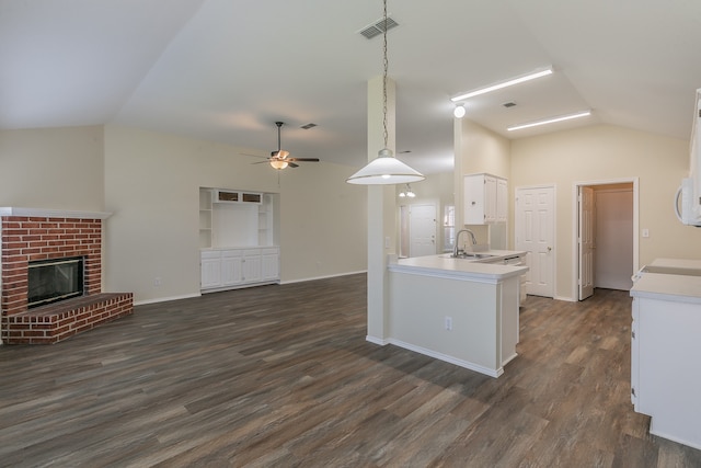 kitchen featuring lofted ceiling, sink, kitchen peninsula, and decorative light fixtures