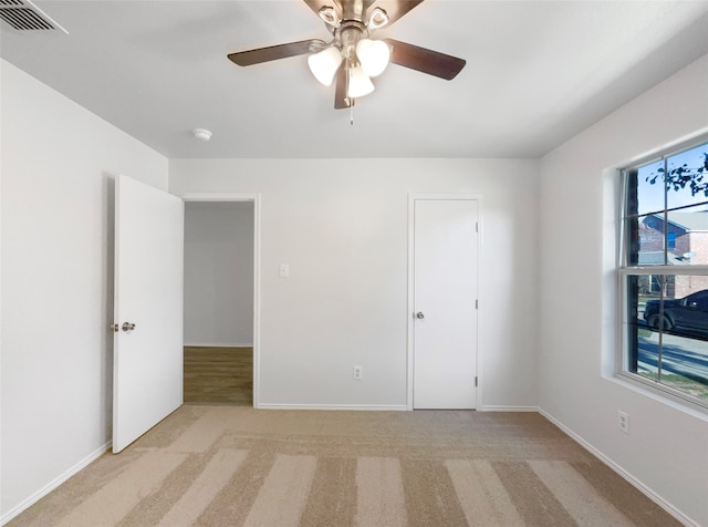 unfurnished bedroom featuring light colored carpet and ceiling fan