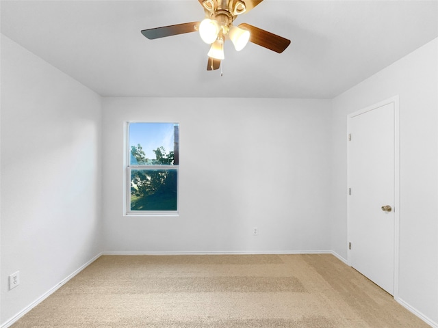 carpeted spare room with ceiling fan