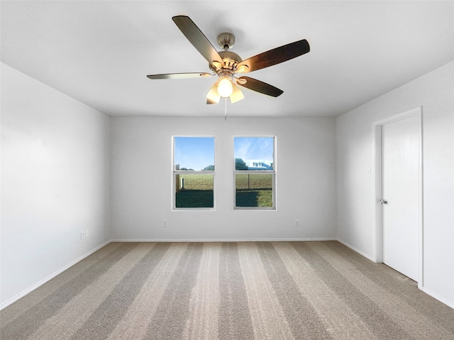 carpeted spare room with ceiling fan