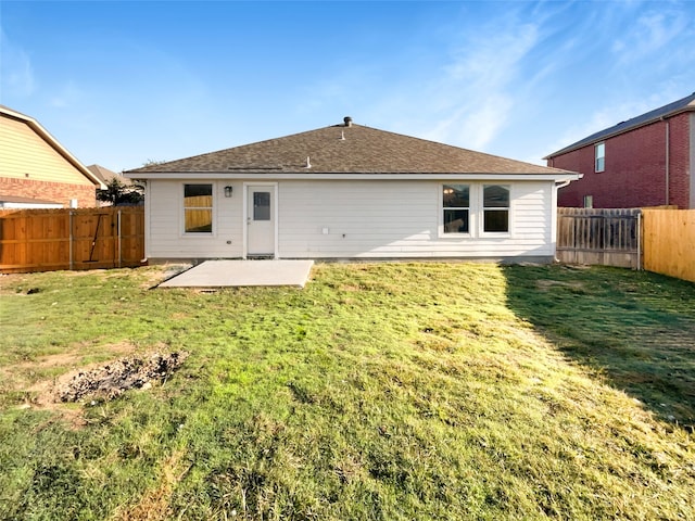 back of house with a yard and a patio