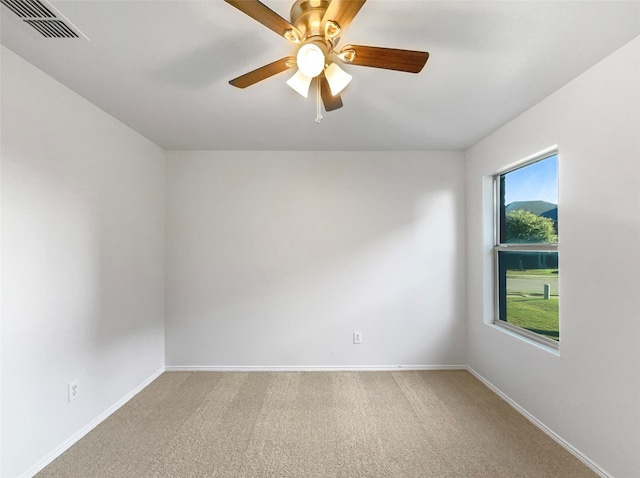 spare room featuring ceiling fan and carpet