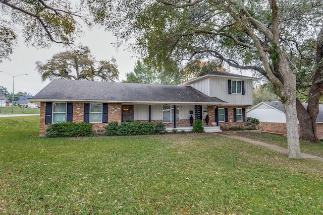 tri-level home featuring a porch and a front lawn